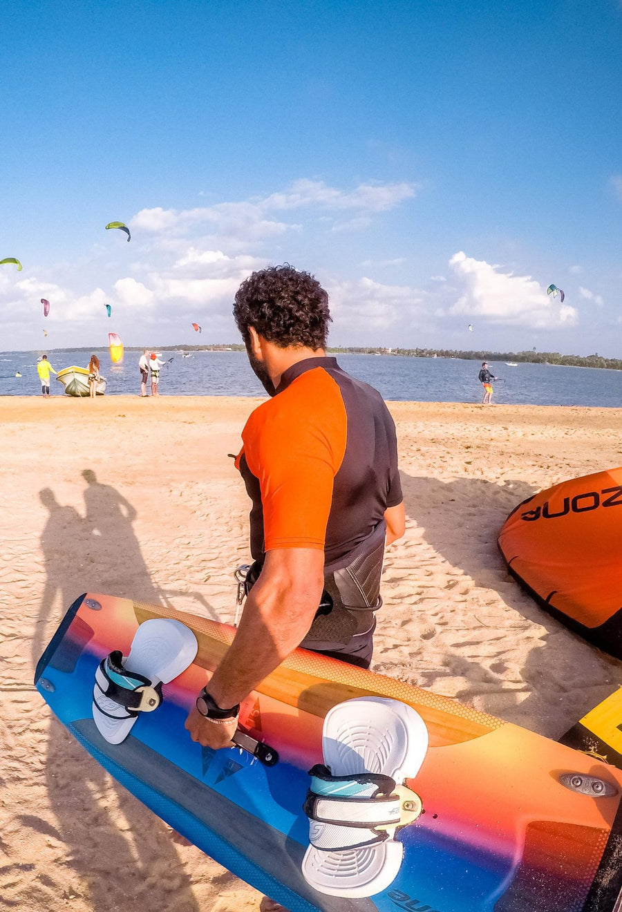 Kitesurfer mit Res-T orange und Board am Strand